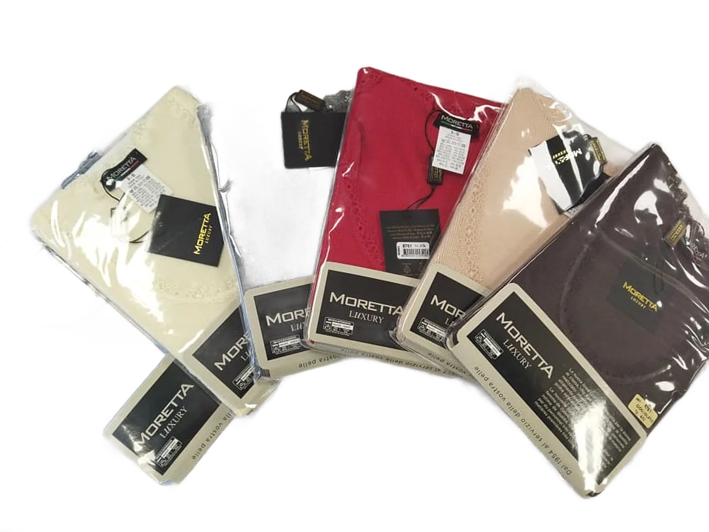 Six hauts en maille de la marque Moretta Luxury, dans leurs emballages plastique, disposés en éventail sur un tissu blanc à relief.